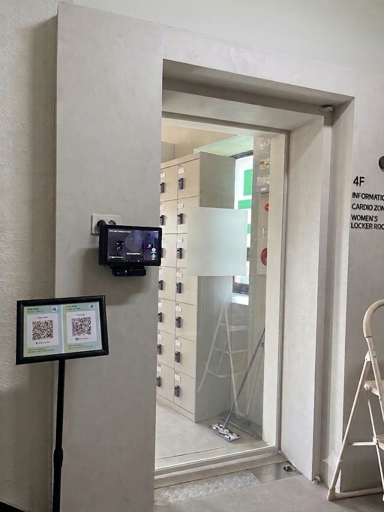 헬스장 현장에 설치된 얼굴인식 키오스크와 QR 안내 단말